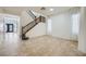 Bright, tiled living room featuring a staircase and large windows with sheer, white curtains at 10428 Mulvaney Cir, Las Vegas, NV 89141