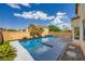 Outdoor in-ground pool with clear blue water, patio area, palm trees, artificial turf and lush landscaping at 10428 Mulvaney Cir, Las Vegas, NV 89141