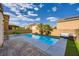 Outdoor pool area with stone patio, palm trees, artificial turf and a view of the house at 10428 Mulvaney Cir, Las Vegas, NV 89141
