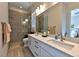 Elegant bathroom with double sinks, quartz countertops, a frameless shower, and wood-look tile flooring at 10972 Dixie Johnson Ave, Las Vegas, NV 89166