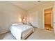 Well-lit bedroom featuring a minimalist design with a cozy chair and closet for storage at 10972 Dixie Johnson Ave, Las Vegas, NV 89166
