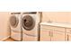Clean laundry room features side-by-side washer and dryer and a utility sink with a white storage cabinet at 10972 Dixie Johnson Ave, Las Vegas, NV 89166