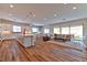 Spacious living room, dining area and kitchen featuring wood floors and natural light at 10972 Dixie Johnson Ave, Las Vegas, NV 89166