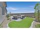 Charming backyard featuring a cozy fire pit area, lush artificial turf, and privacy landscaping at 112 Springbough Ln, Las Vegas, NV 89138
