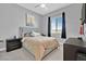 Well-lit bedroom featuring neutral colored walls, a ceiling fan, blackout curtains, and wood bedside table at 112 Springbough Ln, Las Vegas, NV 89138