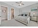 Bright bedroom features neutral tones, a ceiling fan, and an open doorway to an ensuite bathroom and walk-in closet at 112 Springbough Ln, Las Vegas, NV 89138