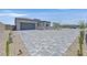 Paver driveway leads to a modern home with a spacious three-car garage and landscaped front yard at 112 Springbough Ln, Las Vegas, NV 89138