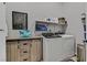 Laundry room featuring a front loading washer and dryer, folding table, and upper shelf at 112 Springbough Ln, Las Vegas, NV 89138