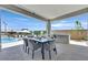 Inviting covered patio with an outdoor dining table and a view of the refreshing pool and landscaping at 112 Springbough Ln, Las Vegas, NV 89138