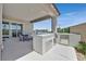 This covered patio features an outdoor kitchen, dining area, and seamless flow to the sparkling pool at 112 Springbough Ln, Las Vegas, NV 89138