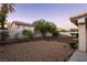 View of the backyard with desert landscaping, mature trees, and block wall fencing at 1206 Evening Canyon Ave, Henderson, NV 89014