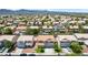 Expansive neighborhood view showcasing a home with a three-car garage, tile roof, and mountain backdrop at 1371 Cumulus Ct, Henderson, NV 89014