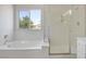 Bright bathroom featuring a tub and a glass shower at 1371 Cumulus Ct, Henderson, NV 89014