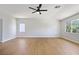 Spacious bedroom featuring wood flooring, a ceiling fan, and bright windows at 1371 Cumulus Ct, Henderson, NV 89014