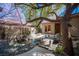 Backyard tranquility: pond, bridge, mature tree, and built-in BBQ create a perfect outdoor retreat at 15 Emerald Dunes Cir, Henderson, NV 89052