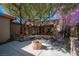 Inviting backyard with mature trees, a small pond, fire pit, and outdoor seating at 15 Emerald Dunes Cir, Henderson, NV 89052
