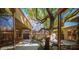 Charming backyard featuring a mature shade tree, concrete patio, rock garden, and sliding doors leading inside the home at 15 Emerald Dunes Cir, Henderson, NV 89052