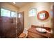 Bathroom with a walk-in shower, arched window, and sink with custom granite countertop at 15 Emerald Dunes Cir, Henderson, NV 89052