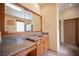 Bathroom featuring walk-in shower, single sink vanity with wood cabinets, and a large framed mirror above at 15 Emerald Dunes Cir, Henderson, NV 89052