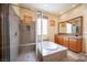 Bathroom showcases walk-in shower, a soaking tub, and double sink vanity with wood cabinets and granite countertops at 15 Emerald Dunes Cir, Henderson, NV 89052