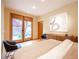 Bright bedroom showcasing hardwood floors, sliding doors to the yard, and neutral walls with a modern wall hanging at 15 Emerald Dunes Cir, Henderson, NV 89052