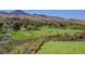 Scenic view of the lush golf course with sand traps and mountain backdrop at 15 Emerald Dunes Cir, Henderson, NV 89052