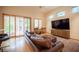 Spacious living room boasts a leather sofa, wooden floors, and modern entertainment center, filled with natural light at 15 Emerald Dunes Cir, Henderson, NV 89052
