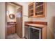 Convenient wet bar with wooden cabinetry and a stainless steel wine fridge at 15 Emerald Dunes Cir, Henderson, NV 89052