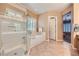 Serene bathroom with neutral tiling featuring a large walk-in shower and soaking tub at 1637 Wellington Springs Ave, Henderson, NV 89052