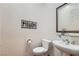 Powder room with a pedestal sink, decorative mirror, and neutral walls at 1637 Wellington Springs Ave, Henderson, NV 89052