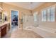 Lavish bathroom boasts double sinks, frameless glass shower, and a separate soaking tub with neutral colors at 1637 Wellington Springs Ave, Henderson, NV 89052