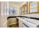 Convenient laundry room includes washer, dryer, storage cabinets, and a utility sink at 1637 Wellington Springs Ave, Henderson, NV 89052