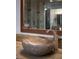 Close-up of the main bathroom featuring a unique stone vessel sink with a chrome faucet and wood-look mirror at 17 Soaring Bird Ct, Las Vegas, NV 89135