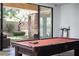 Well-lit game room featuring a pool table with access to the landscaped backyard through sliding glass doors at 17 Soaring Bird Ct, Las Vegas, NV 89135
