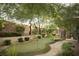 Landscaped backyard features a putting green, mature trees, and a brick perimeter wall at 17 Soaring Bird Ct, Las Vegas, NV 89135
