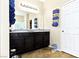 Bathroom with granite countertops, dual sinks, dark cabinets, large mirror and a separate toilet room at 2079 Port Royal Dr, Laughlin, NV 89029