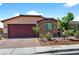 Charming single-story home featuring stone accents, a red garage door, and well-maintained landscaping at 2079 Port Royal Dr, Laughlin, NV 89029
