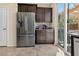 Modern kitchen featuring stainless steel appliances, dark cabinetry, and a sliding glass door at 2079 Port Royal Dr, Laughlin, NV 89029
