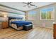 Spacious main bedroom with blue accent wall, hardwood floors, ceiling fan, and lots of natural light at 2079 Port Royal Dr, Laughlin, NV 89029