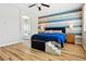 Spacious main bedroom with hardwood floors, ceiling fan, blue accent wall, and attached bathroom at 2079 Port Royal Dr, Laughlin, NV 89029