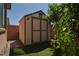 Outdoor shed with double doors, set in a well-manicured yard with artificial turf at 2079 Port Royal Dr, Laughlin, NV 89029