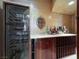 Elegant bar area featuring a wine fridge, marble countertop, and display shelves for bottles at 2200 Glenbrook Way, Las Vegas, NV 89117