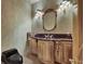 Stylish powder room featuring custom vanity with dark countertop, sconce lighting, and modern fixtures at 2200 Glenbrook Way, Las Vegas, NV 89117