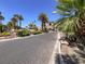 Long brick driveway leading to an exclusive community entrance surrounded by tropical landscaping at 2200 Glenbrook Way, Las Vegas, NV 89117