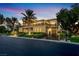 Elegant two-story home showcasing manicured landscaping, a circular driveway, and ambient outdoor lighting at 2200 Glenbrook Way, Las Vegas, NV 89117