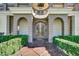 Elegant front door with ornate detailing and arched entryway, framed by manicured hedges at 2200 Glenbrook Way, Las Vegas, NV 89117