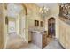 Hallway features a custom wine storage and marble floors, leading to various rooms in the home at 2200 Glenbrook Way, Las Vegas, NV 89117