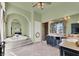 Luxurious primary bath with a jacuzzi tub, marble floors, and custom cabinetry at 2200 Glenbrook Way, Las Vegas, NV 89117