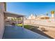 Home's backyard features a covered patio, decorative rock, artificial turf, and perimeter block wall at 2229 Bowstring Dr, Las Vegas, NV 89142