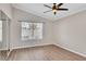 Neutral bedroom features plank flooring, ceiling fan and window overlooking exterior at 2229 Bowstring Dr, Las Vegas, NV 89142